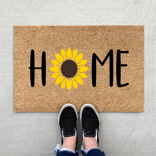 Floral entrance door mat with blue blooms and green foliage on brown