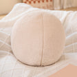 Hayman beige boucle round ball cushion on a sofa