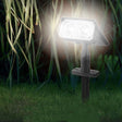 Solar spot light on a stake illuminating a garden feature tree