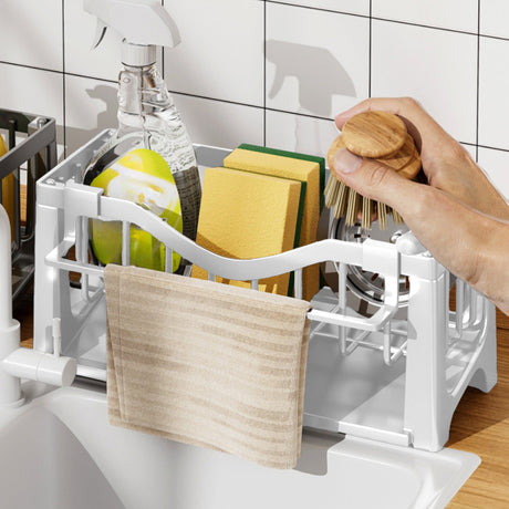 Compartments of the sink caddy holding assorted cleaning tools
