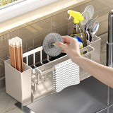 Compartments of the sink caddy holding assorted cleaning tools