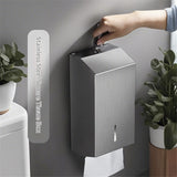 Paper towel being drawn from the base of the stainless steel dispenser