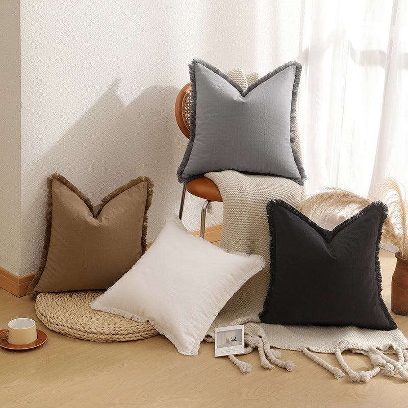 Close up of the textured brown fabric and fringed edge on the cushion cover