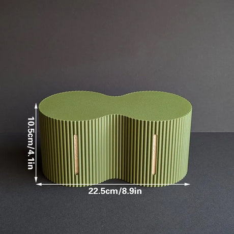 Light green roll storage box beside a toilet with spare rolls inside