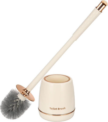 Gold toilet brush and holder set standing beside a toilet