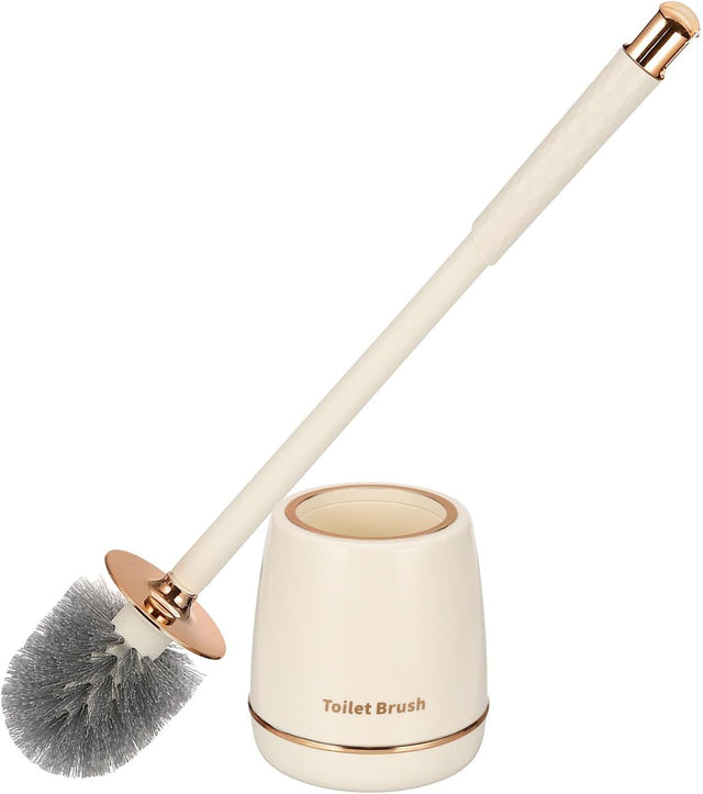 Gold toilet brush and holder set standing beside a toilet