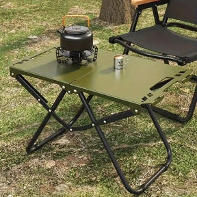 Green folding camp table with iron frame open and ready for outdoor use