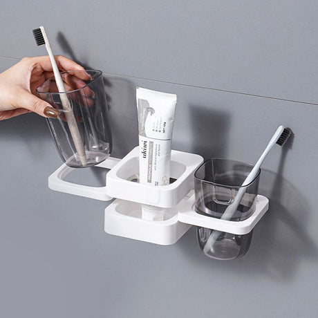 White organiser holding toothbrushes, toothpaste and a mouthwash cup