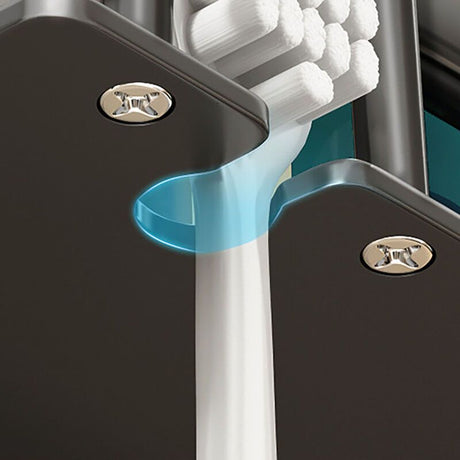 Grey toothbrush holder holding electric toothbrushes and cups on a tiled wall