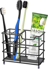 Black stainless steel freestanding toothbrush holder with four brush slots on a bathroom vanity