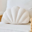 Wentworth Falls ivory plush seashell cushion on a bed