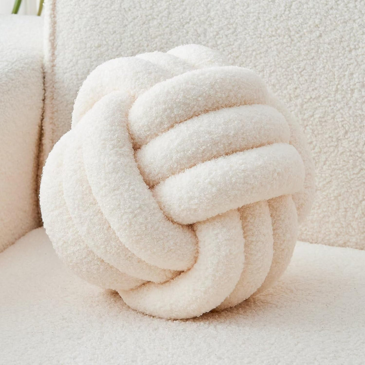 Blackheath ivory white lambswool knot cushion on a sofa