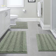 Sage striped chenille bathroom rug set of three pieces laid out on a floor