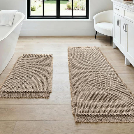Cream waffle bath mat set of two with tassels laid on a bathroom floor