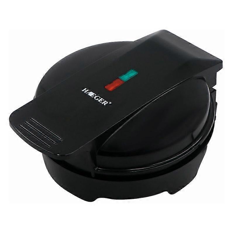 Mini waffle maker closed on a kitchen bench with indicator light on the lid