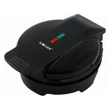 Mini waffle maker closed on a kitchen bench with indicator light on the lid