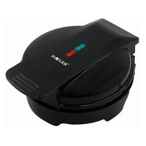 Mini waffle maker closed on a kitchen bench with indicator light on the lid