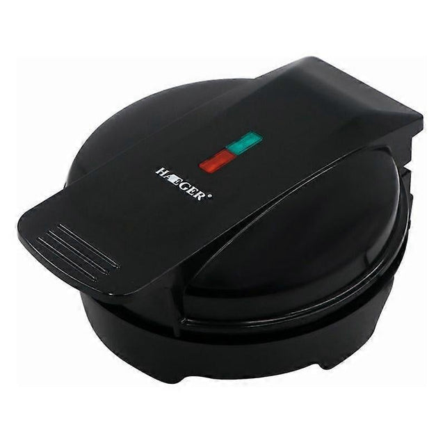 Mini waffle maker closed on a kitchen bench with indicator light on the lid