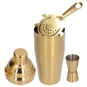 Merricks golden stainless steel cocktail shaker set with strainer and measuring cup on a bar