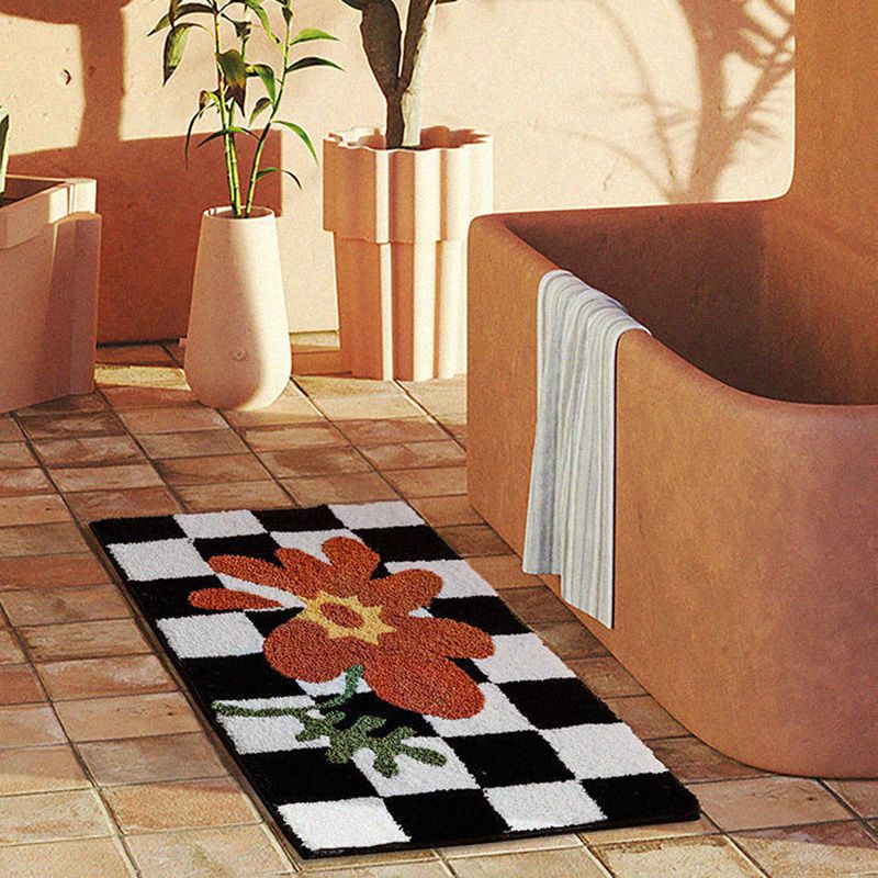 Close up of the polyester fibre pile on the checkered orange flower doormat