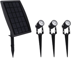 Booral solar garden spotlights in warm white lighting a feature wall and planting bed at dusk