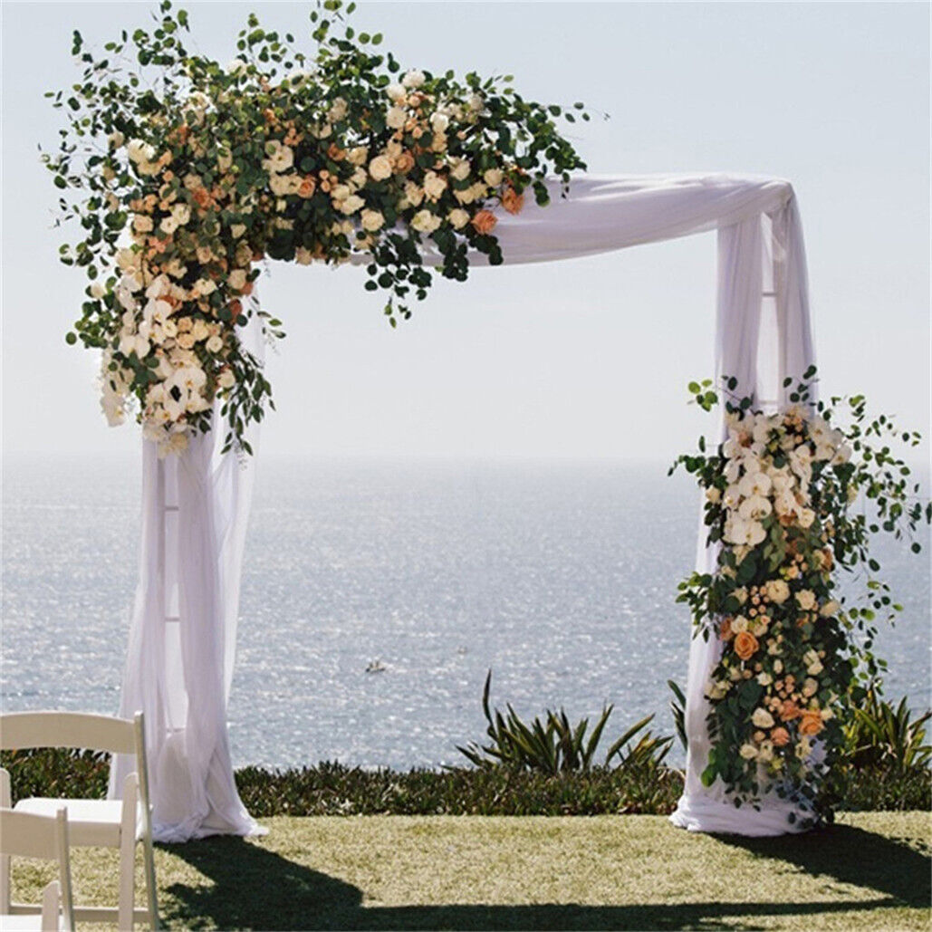Front on view of the white metal arbour framing a garden pathway