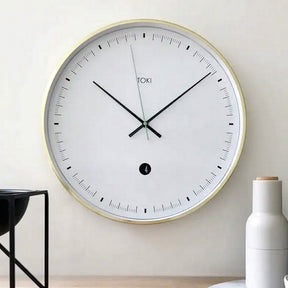 Audrey brushed gold wall clock with white dial in an elegant living room