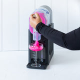 Juice being poured into the slushie maker between the minimum and maximum fill