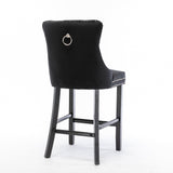 Ranelagh black velvet bar stool with silver stud trim and wooden legs in a dining room