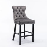 Waterways grey velvet bar stool with silver stud trim and wooden legs in a dining room