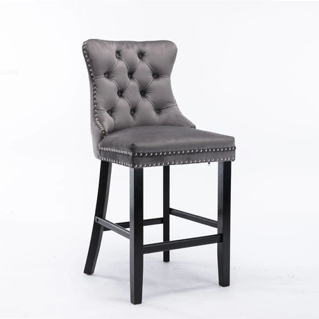Waterways grey velvet bar stool with silver stud trim and wooden legs in a dining room