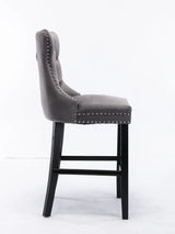 Waterways grey velvet bar stool with silver stud trim and wooden legs in a dining room