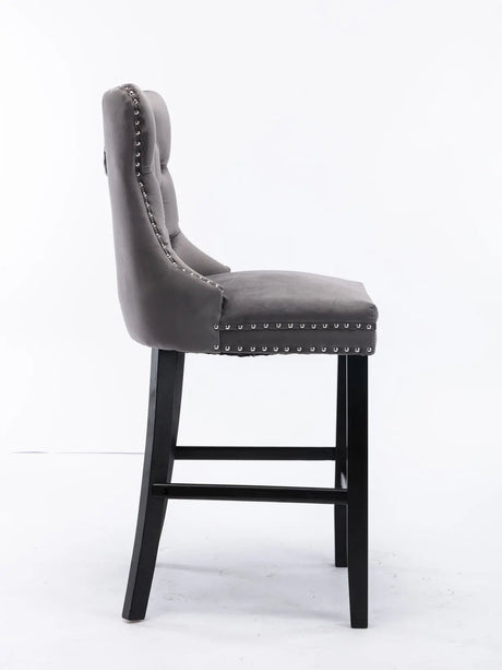 Waterways grey velvet bar stool with silver stud trim and wooden legs in a dining room