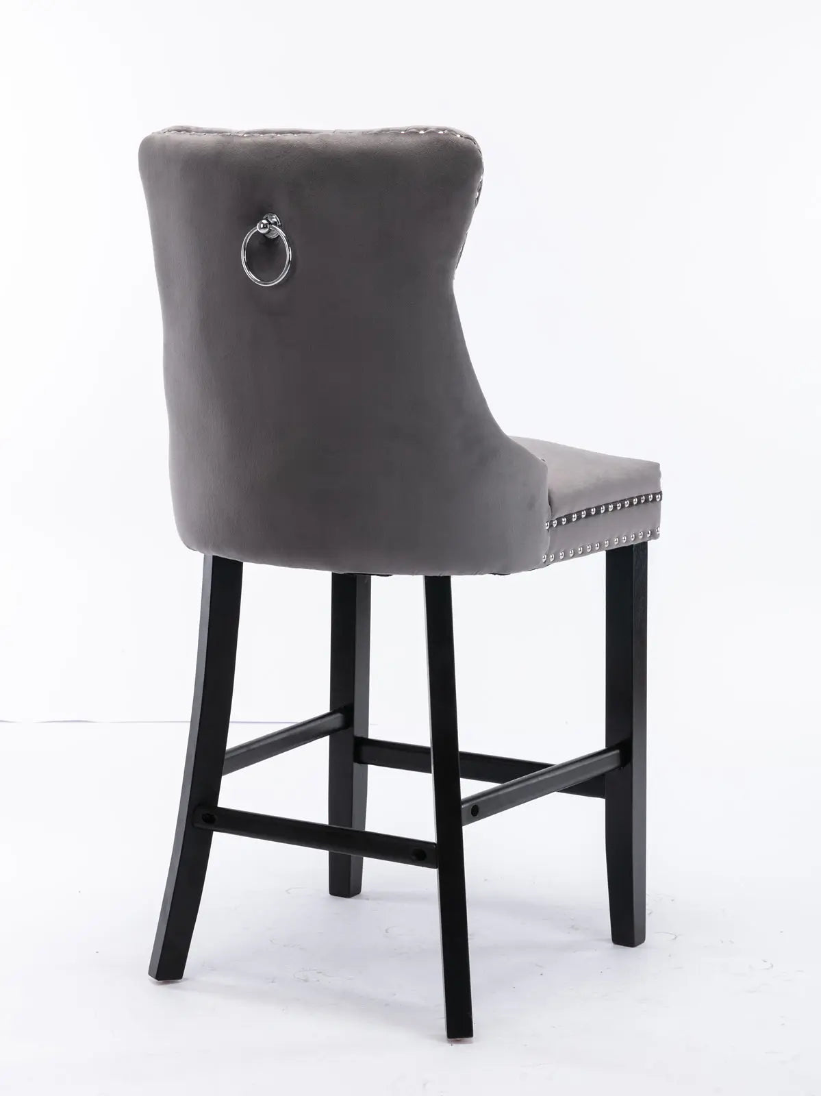 Waterways grey velvet bar stool with silver stud trim and wooden legs in a dining room
