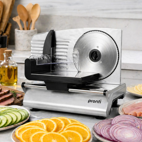 White electric food slicer with sliced bread and vegetables on bench