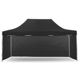 Black pop up gazebo 3 x 4.5 m set up on grass with the roof extended