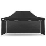 Zip up door panel of the black gazebo tied open for guests to walk through
