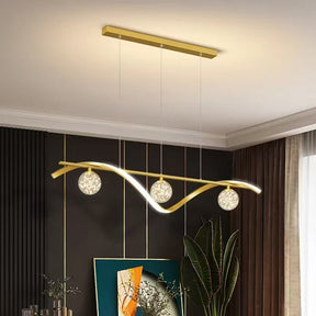 Portofino gold hand blown glass LED pendant above a dining table