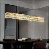 Linear gold crystal chandelier over a dining table