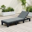 Rattan wicker reclining sun lounger beside a pool