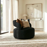 Empress black Milan fabric swivel armchair in a modern living room