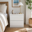 Nimbin warm white two drawer bedside table with finger pull drawers in a compact bedroom