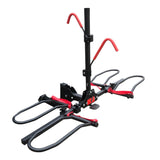 Foldable hitch mounted platform rack carrying two e bikes behind a vehicle