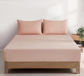 Montalcino pink vintage washed cotton fitted sheet set on a bed
