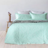 Glacier leaf embossed coverlet with two pillowcases on a Queen King bed