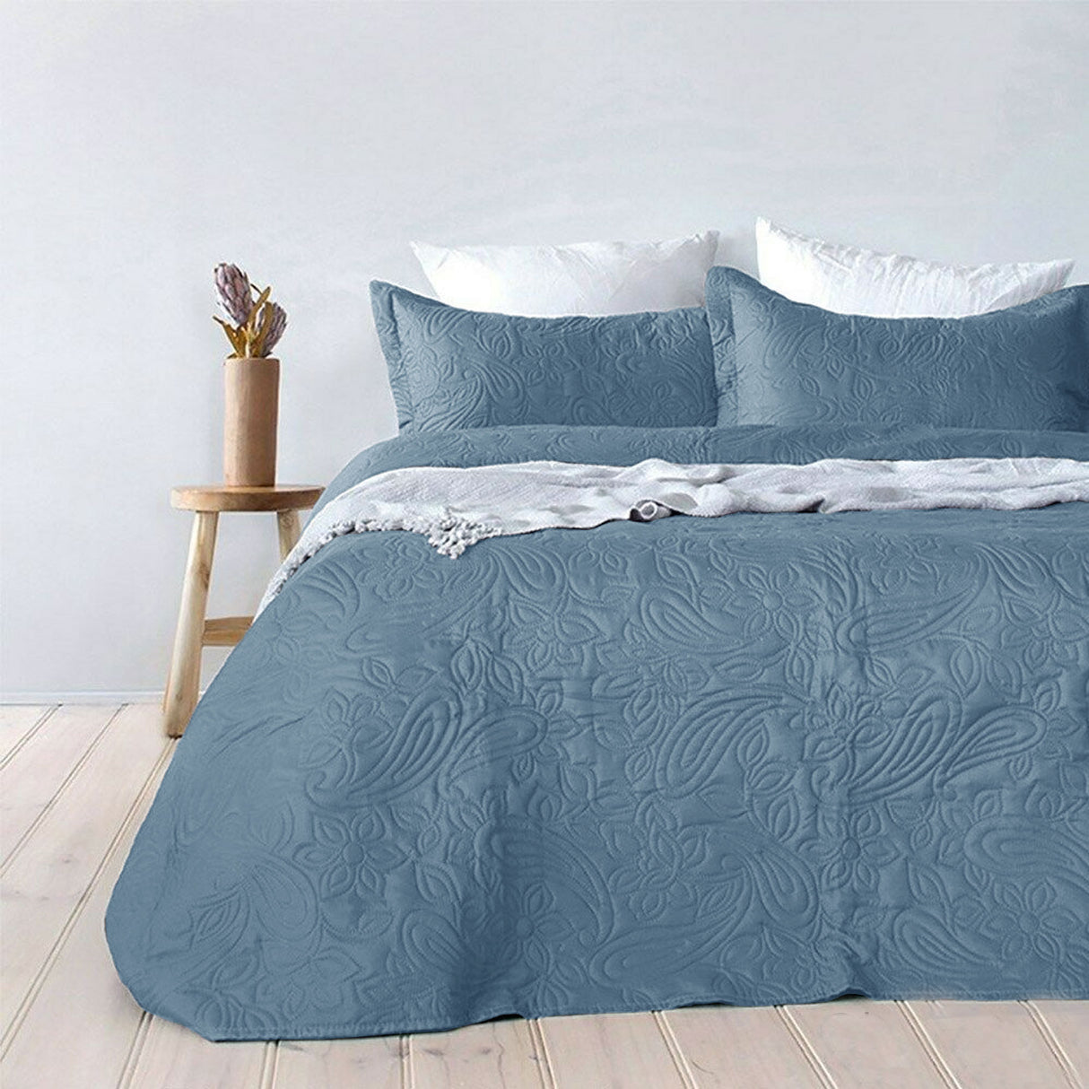Blue paisley embossed coverlet with two pillowcases on a Queen King bed