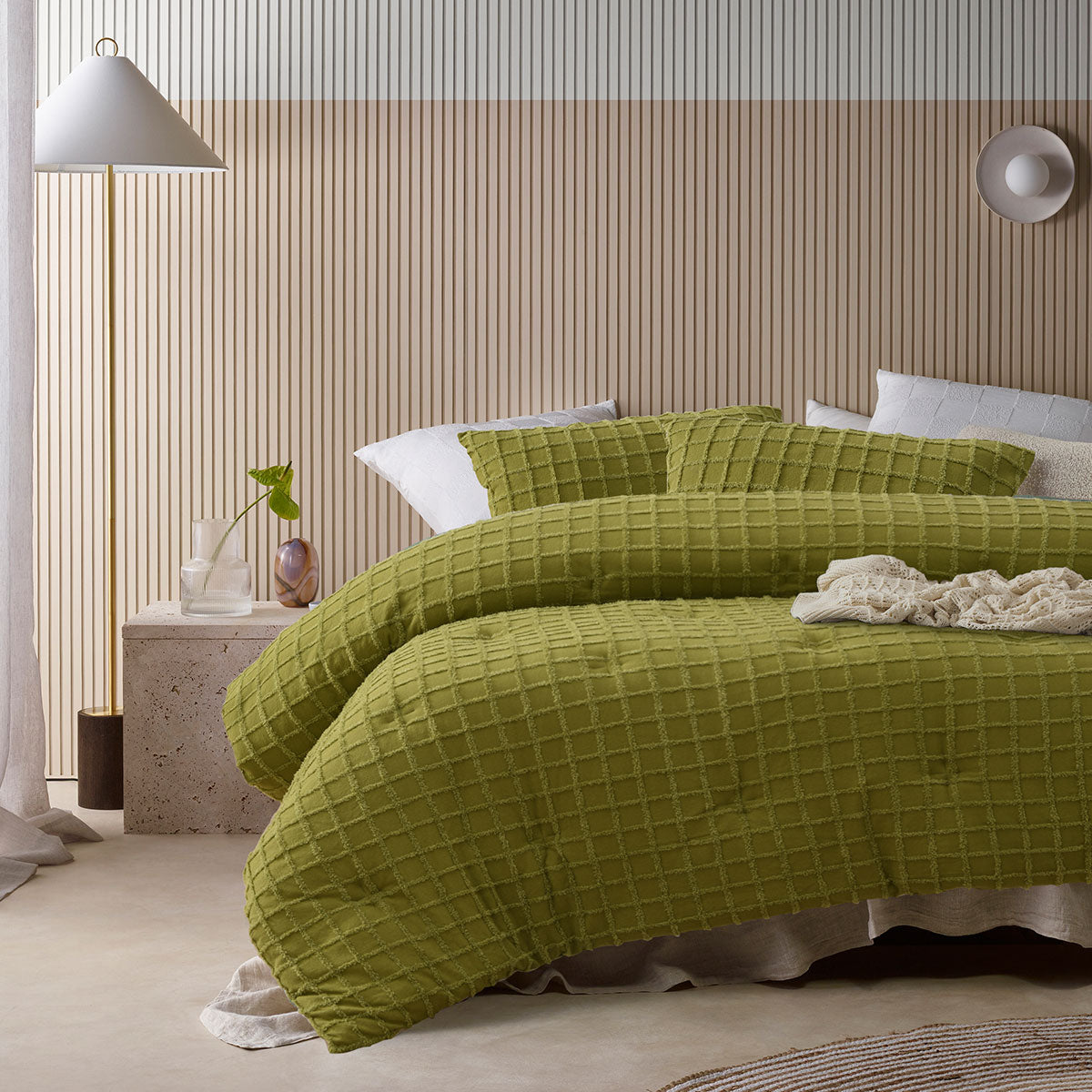 Green comforter set with a geometric parquet print and two pillowcases on a queen bed