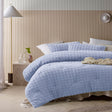 Blue comforter set with a geometric parquet print and two pillowcases on a queen bed