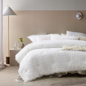 White comforter set with a tonal geometric parquet print and two pillowcases on a queen bed