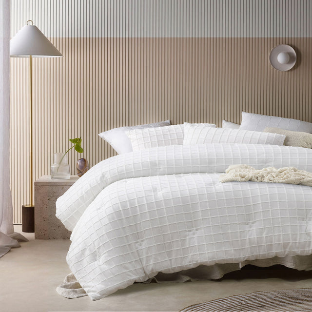 White comforter set with a tonal geometric parquet print and two pillowcases on a queen bed